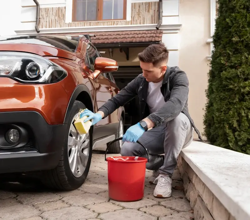 Lavage auto à domicile Abbéville-la-Rivière : professionnel intervenant sur un véhicule